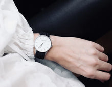 Montre Tweed Co. Anna portée au poignet, style chic et raffiné en tenue blanche